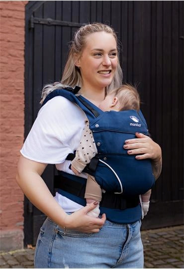 MANDUCA First nosidełko klamrowe bawełna ORGANIC, mama nosi dziecko w pozycji M w granatowym nosidle