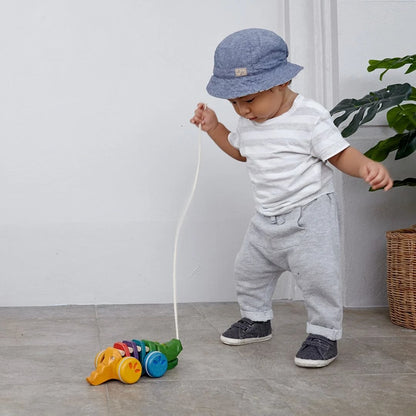 Dziecko ciągnące aligatora PlanToys na sznurku